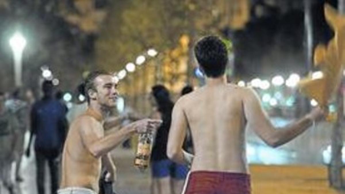 Dos turistas pasean semidesnudos por la Barceloneta, el viernes.