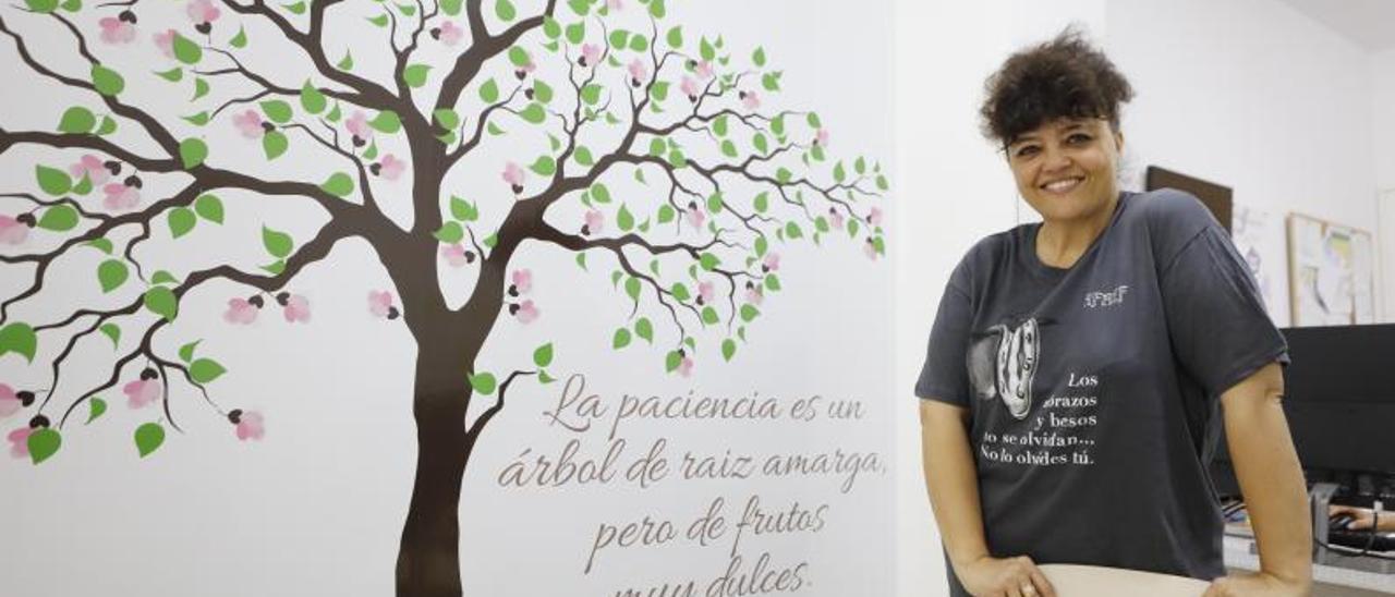 Rosa Sánchez, con el árbol pintado en una de las paredes de la sede de la asociación.