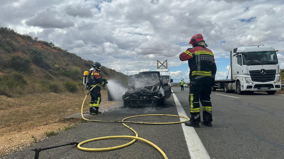 Bomberos trabajan en la extinción del incendio en el vehículo