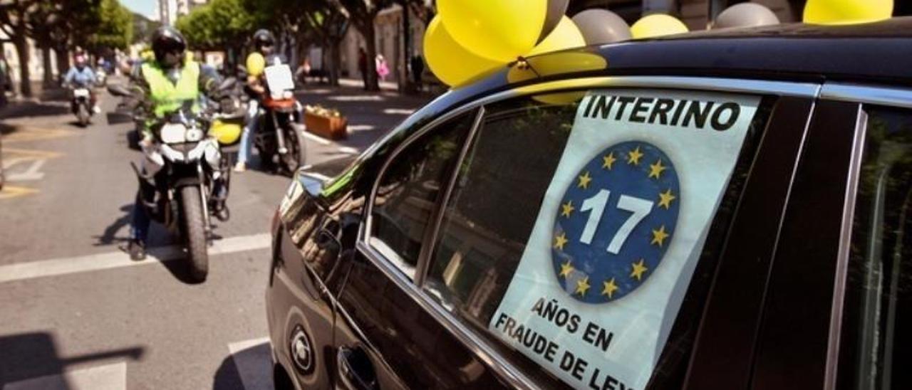 Manifestación de interinos en una caravana de vehículos.