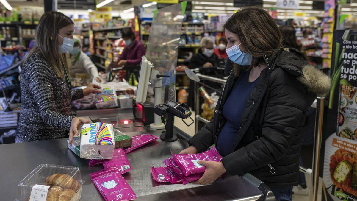 Una mujer hace acopio de mascarillas en un supermercado de Portugal