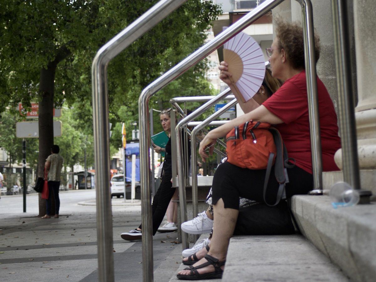 Una mujer, abanico en mano, este martes sentada en una escalera de la Gran Vía de Murcia.