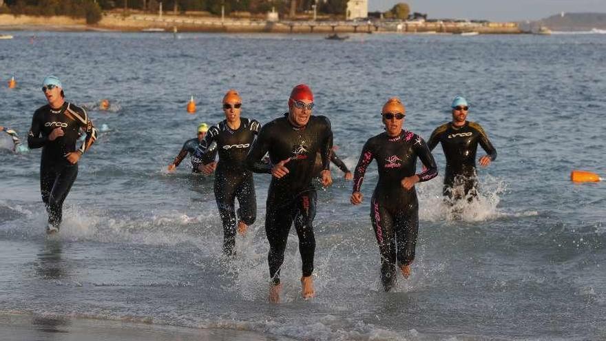 Participantes en la pasada edición concluyen el segmento de natación. // R. Grobas