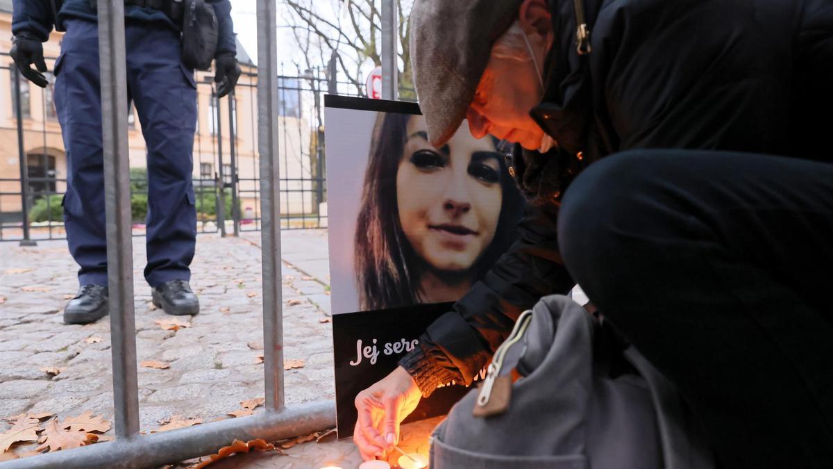 Un hombre enciende una vela en recuerdo de la joven fallecida.