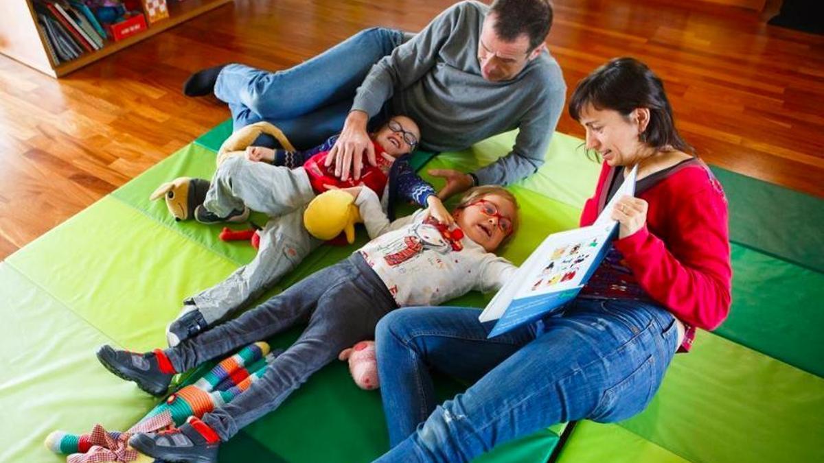 Miquel y Andrea, gemelos que tienen Parkinson, en su casa con sus padres Laura y Andreu.