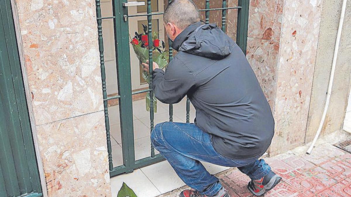 Allegados de la víctima colocan flores en el portal. | TONY SEVILLA