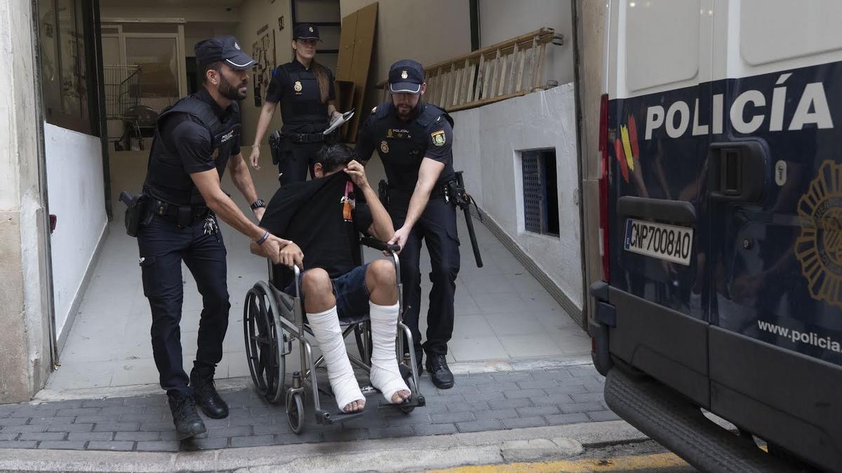 Uno de los detenidos ha salido en silla de ruedas y escoltado por agentes de la Policía Nacional.