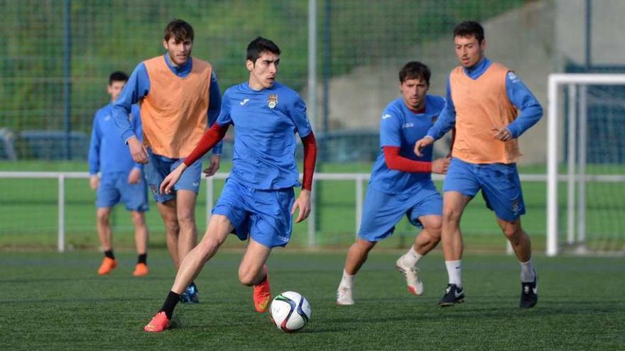 Anxo, seguido de Bruno, Kevin y Mouriño, conduce un balón durante una sesión de entrenamiento en Príncipe Felipe. // G. Santos