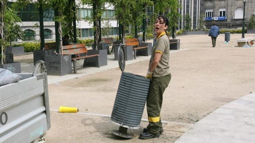 Una operaria colocando una de las papeleras de la plaza de Portugal, ayer a mediodía.