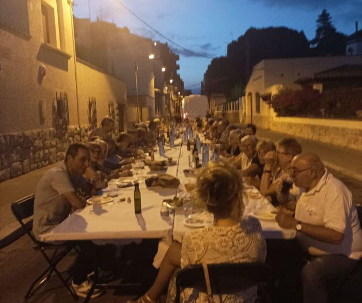 Una imatge del sopar popular d’estiu celebrat al carrer Concòrdia, una perspectiva del jardí Enric Morera amb l’estany central sense aigua  i sense zona de jocs, i l’antic local dels Cunicultors,  on hi ha d’haver la seu de l’Associació de Veïns. | AV/JUDITH BARCELÓ/SANTI COLL