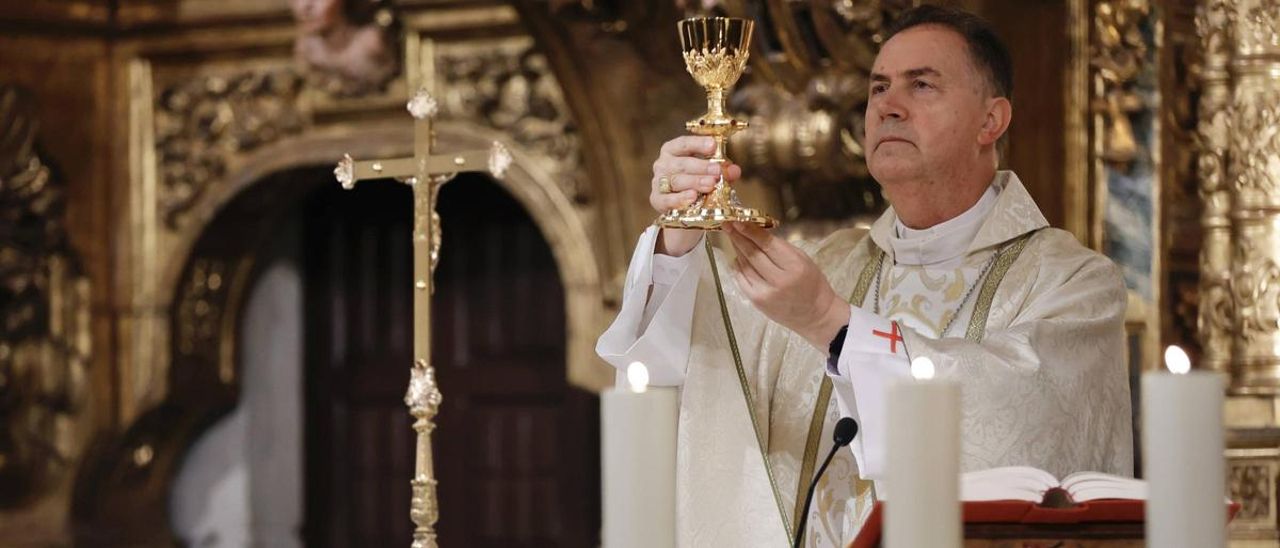 Ángel Fernández Artime, vestido de sacerdote, levanta el caliz en el momento de la consagración del vino.