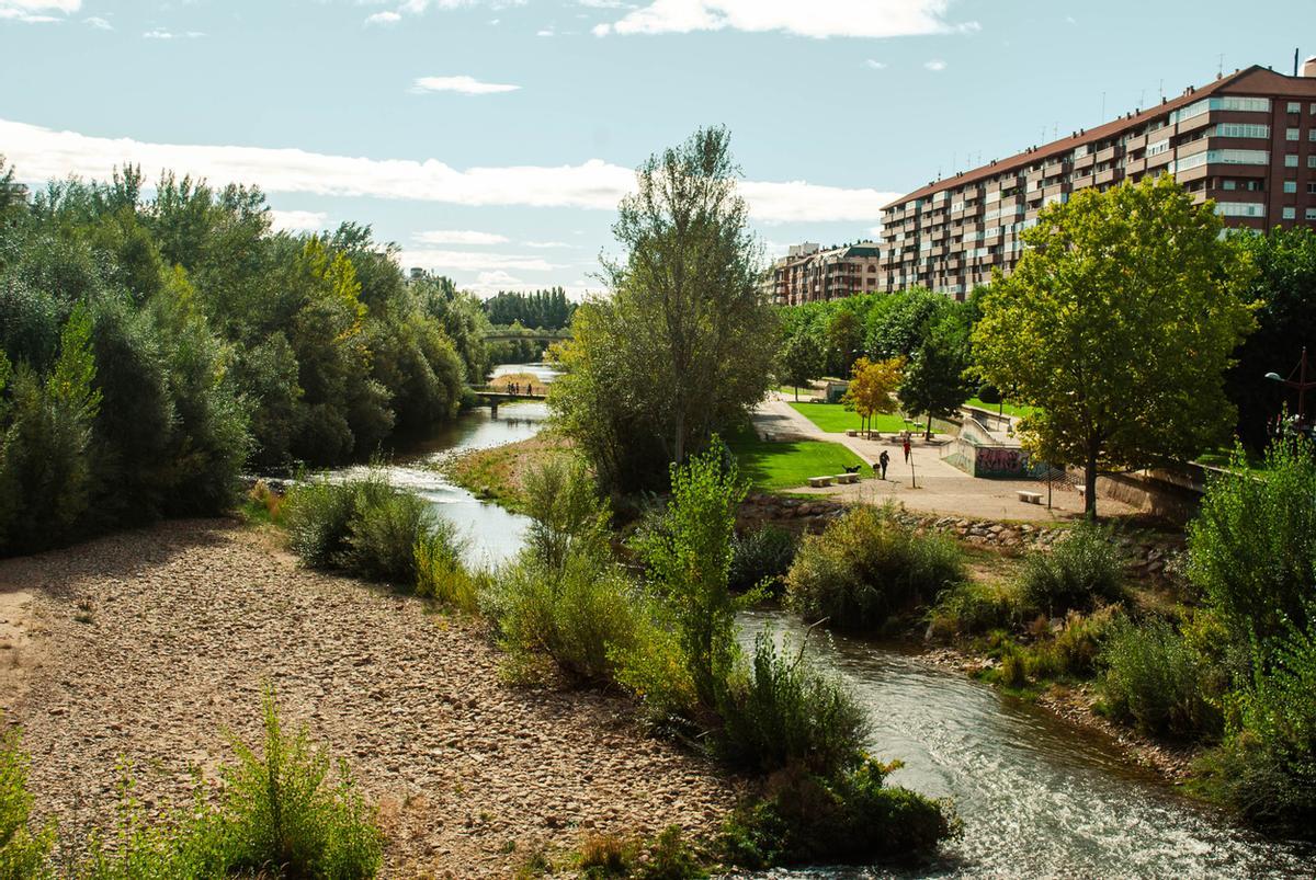 El río Bernesga fluye a través de la ciudad de León en un día soleado
