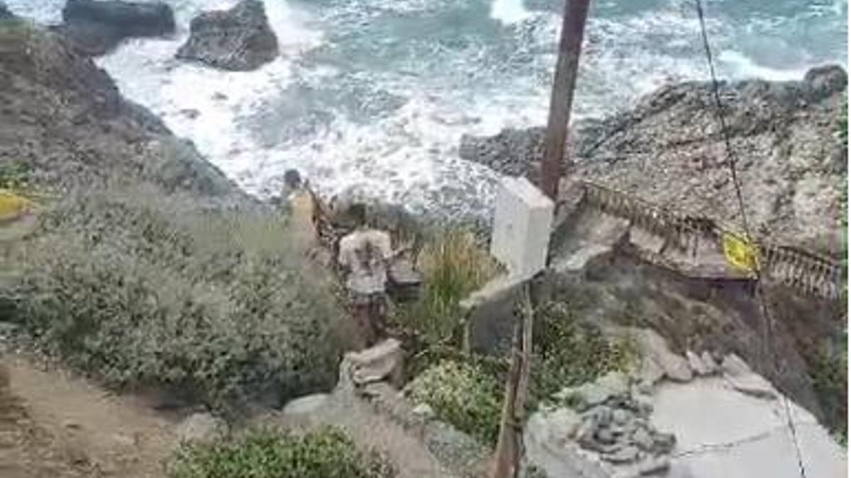 Varias personas saltan las vallas para acceder a la playa de Benijo.