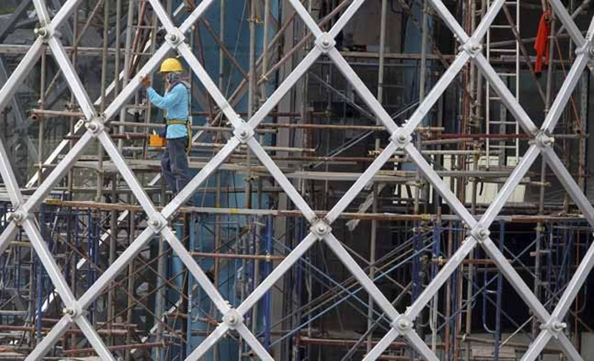 Un obrer treballa en una construcció al centre de Bangkok (Tailàndia). Els pronòstics estimen que l’economia tailandesa podria créixer d’un 3 a un 5 per cent el 2011, per l’augment de les exportacions i el consum.