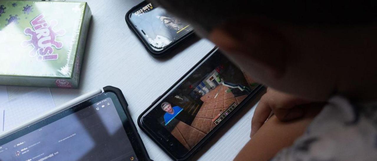 Un niño utiliza un teléfono móvil y una tablet. | E. P.
