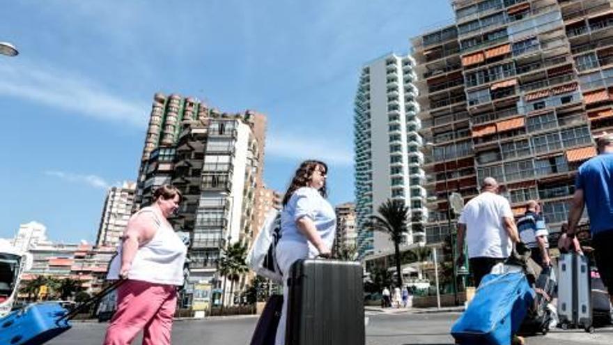 Un grupo de turistas cargados de maletas llega a Benidorm.