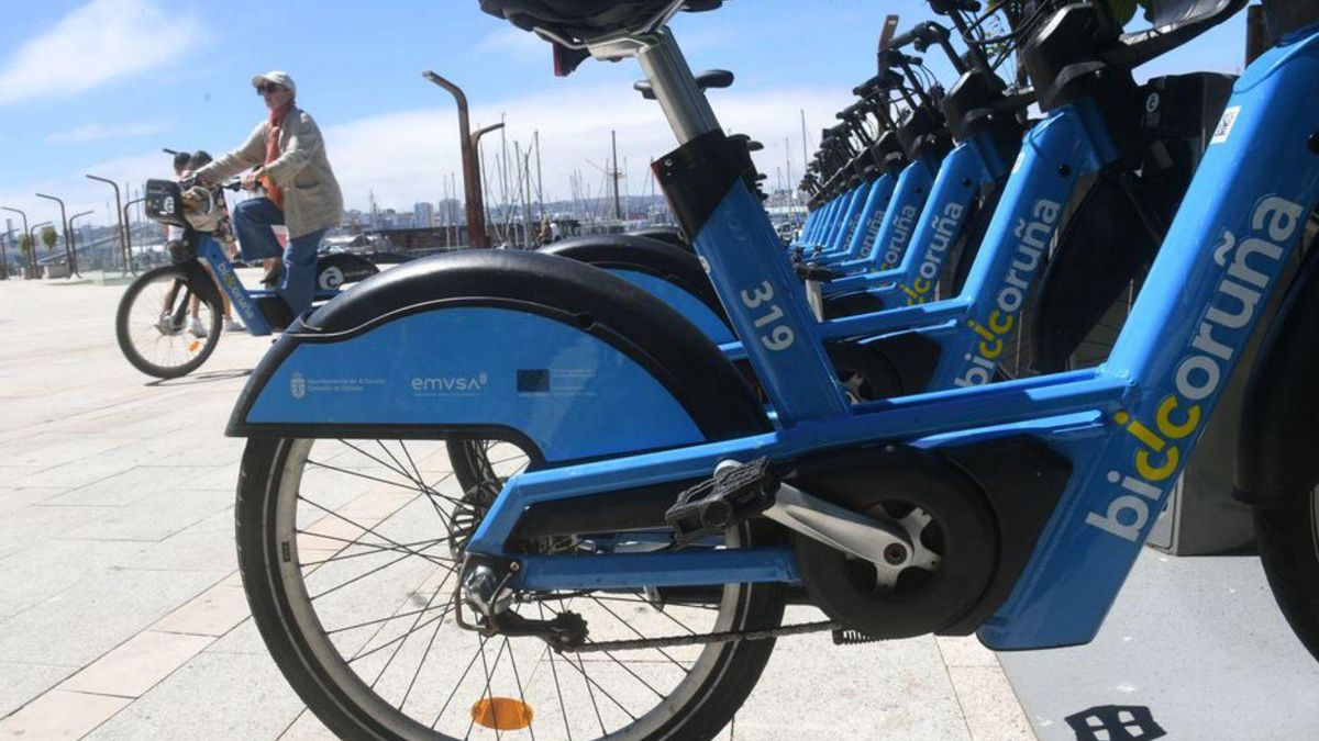 Bicicletas de BiciCoruña y un usuario en Puerta Real. | C. Pardellas
