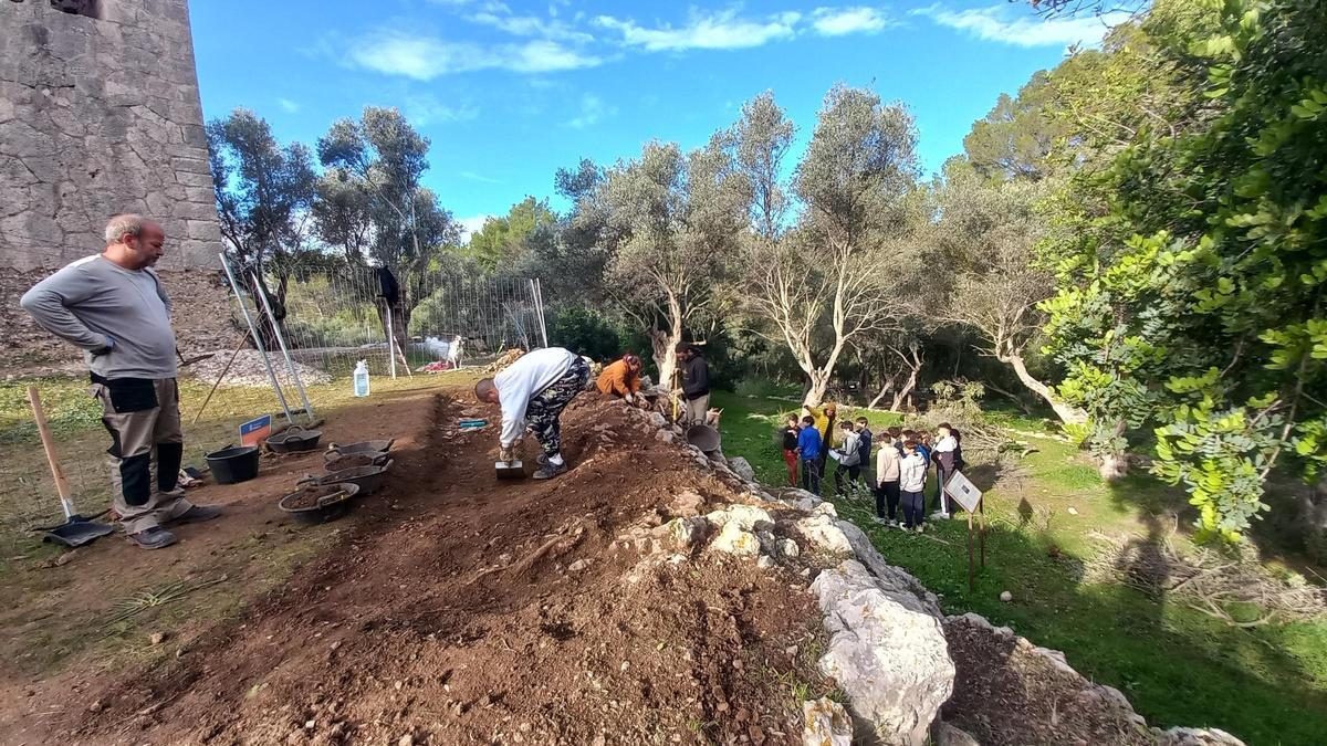El coordinador, Joan Miquel Morey (izda.), con otros miembros y un grupo de alumnos en la muralla talayótica de Crist Rei, en Selva