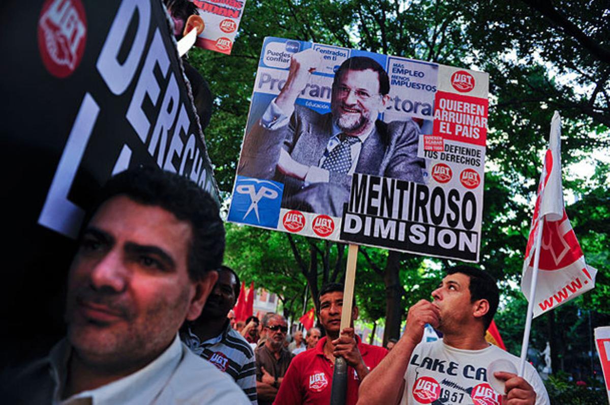 Els manifestants aguanten pancartes en contra de Mariano Rajoy, durant les protestes contra les retallades del Govern, a Pamplona.