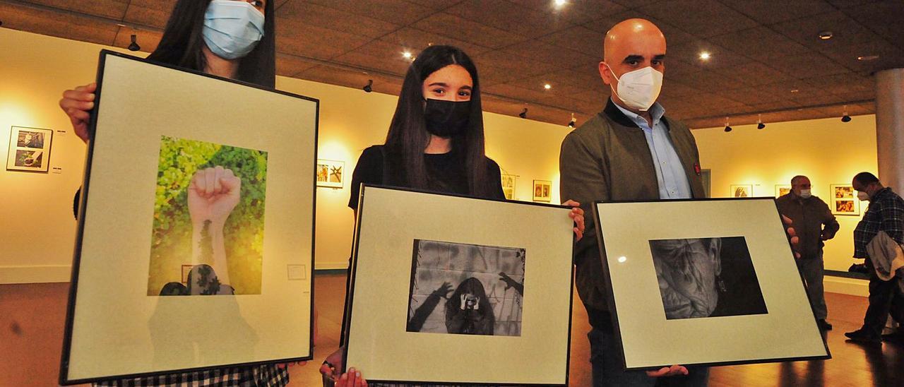 Olaya Paulos, Daniela Nogueira y José Ramón Miguéns muestras las fotografías con las que ganaron el certamen.