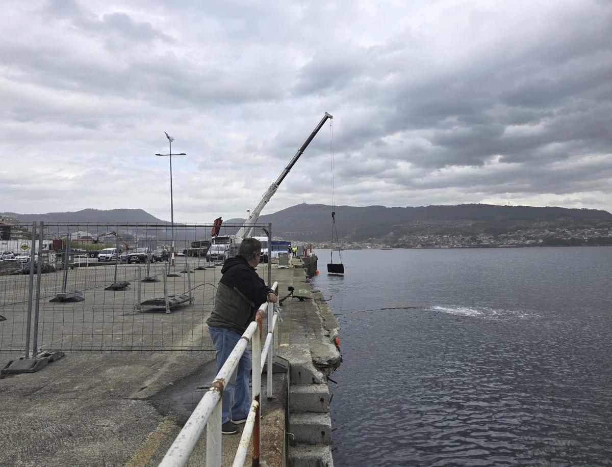 La grúa retiró ayer faldones laterales del muelle que el oleaje había arrancado y estaban en el fondo del mar. | GONZALO NÚÑEZ