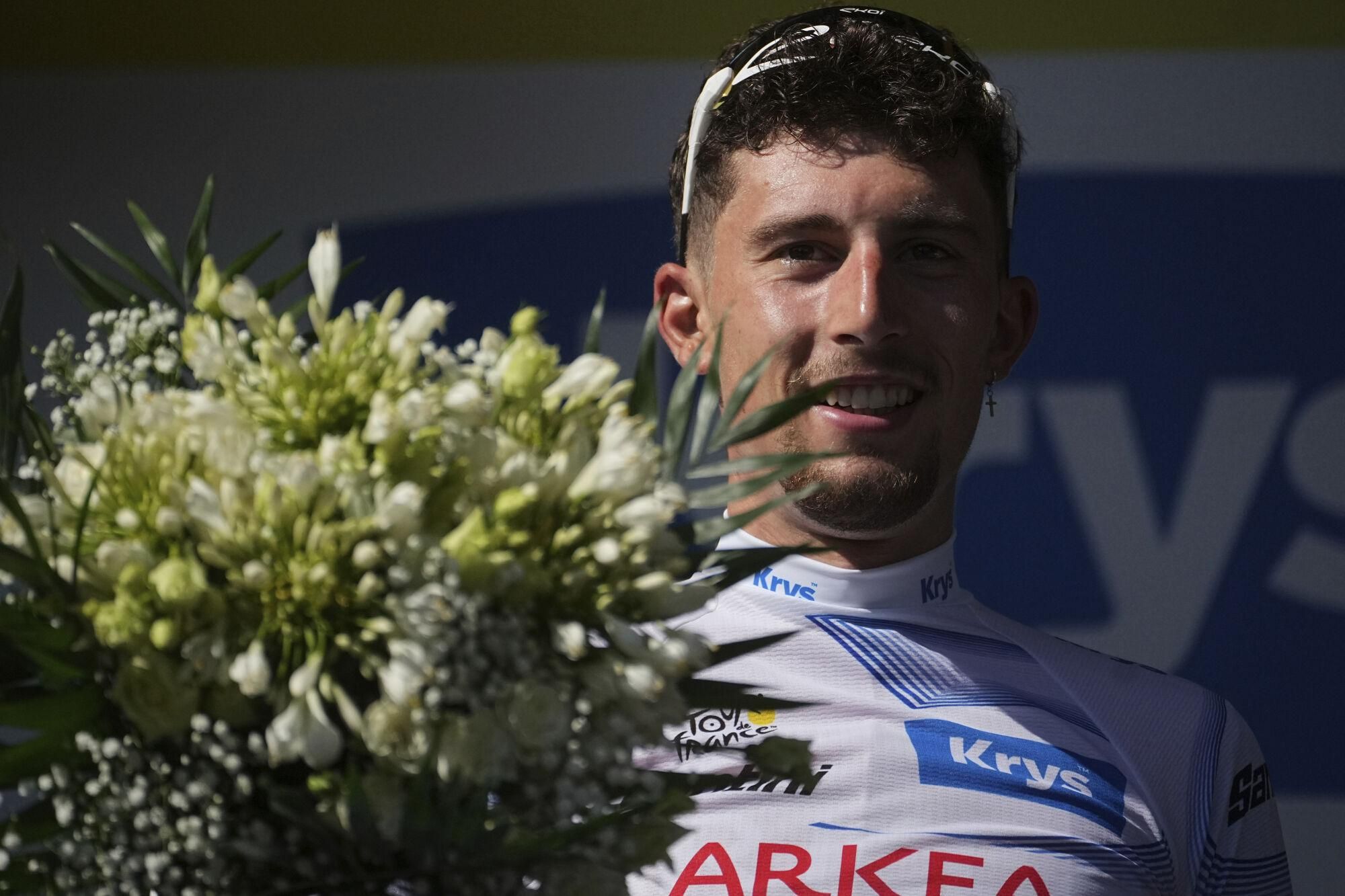 France's Kevin Vauquelin, wearing the best young rider's white jersey celebrates on the podium after the fourth stage of the Tour de France cycling race over 172.2 kilometers (107 miles) with start in Amiens and finish in Rouen, France, Tuesday, July 8, 2025. (AP Photo/Thibault Camus)