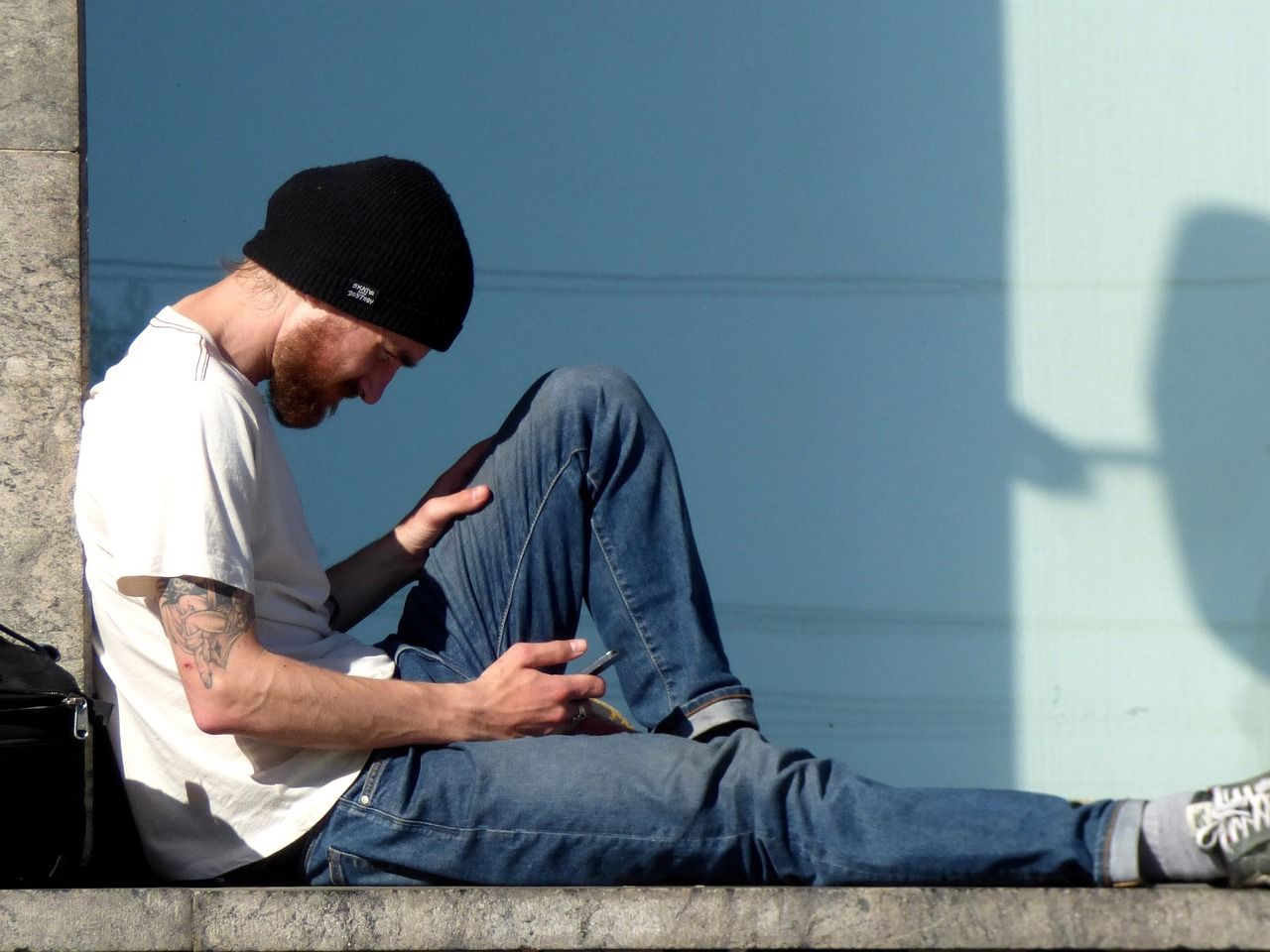 Un chico joven consulta su teléfono móvil.