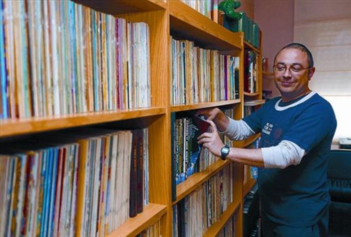 Miguel Ángel Sepúlveda, davant una prestatgeria amb llibres, a casa.seva