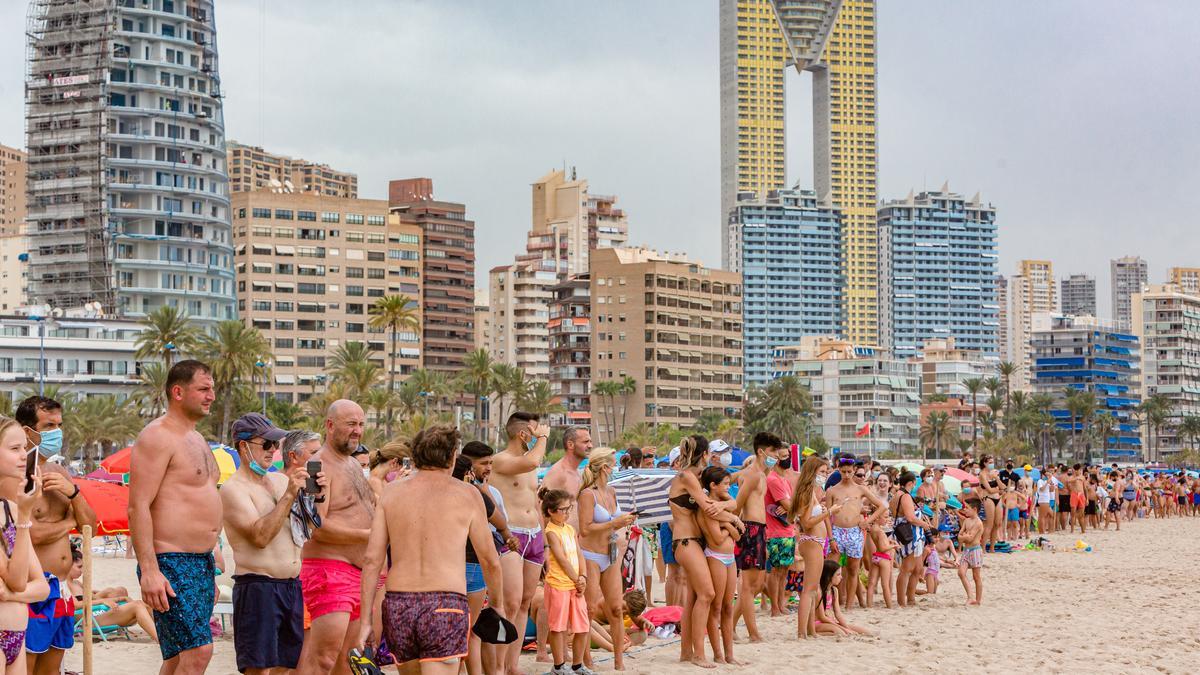 Bañistas contemplan en la orilla de Benidorm la operación de ayuda a la tintorera