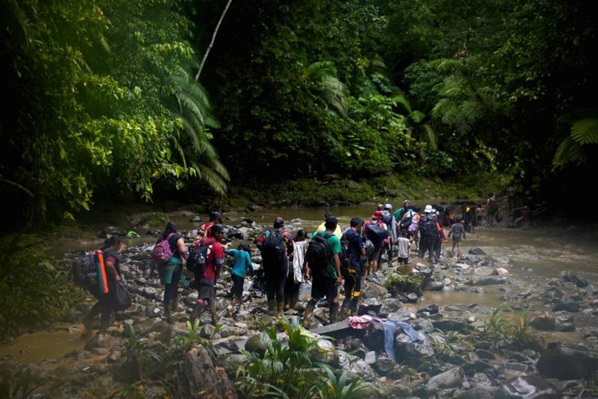 Migrantes cruzan el río Muerto en el Tapón del Darién, de viaje hacia los Estados Unidos, en Acandi, Colombia