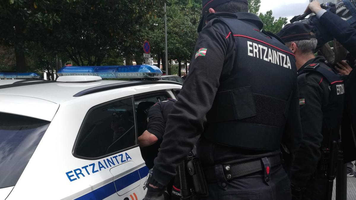 Agentes de la Ertzaintza introducen en el coche policial al detenido por su los homicidios de homosexuales en Bilbao.