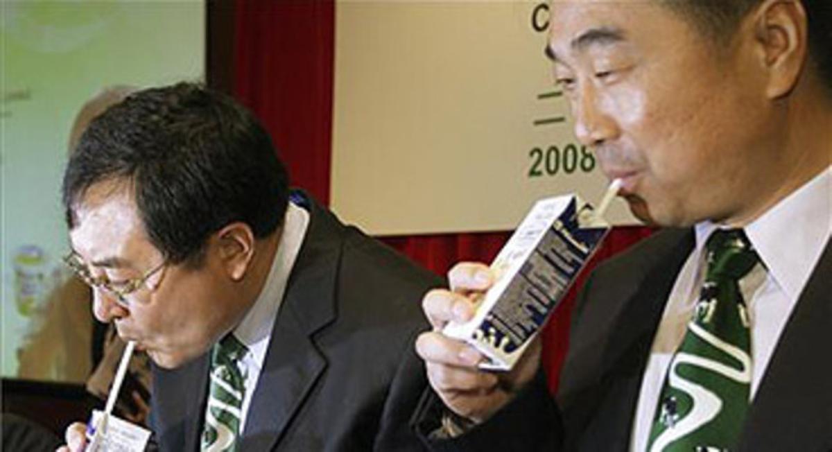 Directores de la empresa láctea china Mengniu Dairy beben sus productos en Hong Kong.