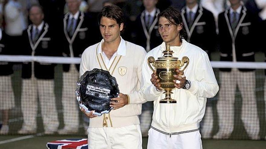 Roger Federer y Rafa Nadal posan con sus trofeos en la pista central del All England Tennis Club.