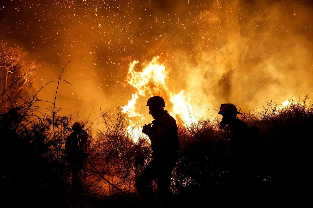 Los bomberos trabajan para apagar un incendio en un campo abierto, tras una infiltración masiva de hombres armados de Hamás desde la Franja de Gaza, cerca de un hospital en Ashkelon, en el sur de Israel.