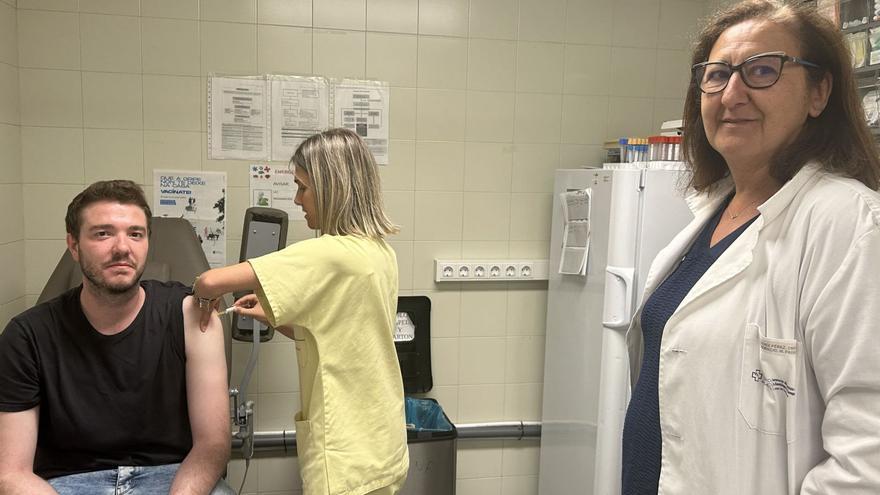 Una enfermera de Medicina Preventiva del CHUS administrando una vacuna a un viajero, junto a Cristina Fernández, la jefa del servicio