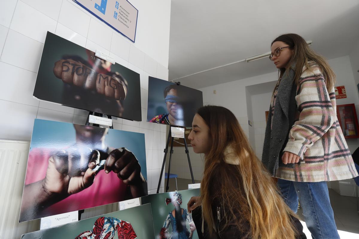 Unas jóvenes observan las imágenes de la muestra.