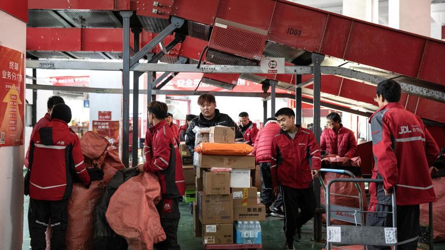 Trabajadores de una plataforma logística en Pekín, con paquetes de compras para ser entregados el 'día del soltero'.