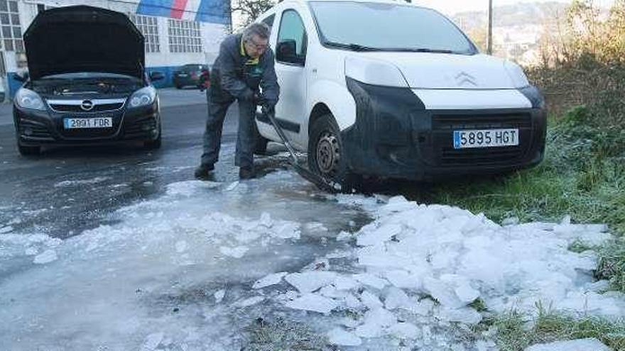 Un hombre retira hielo de la calzada en Seixalbo. // Iñaki Osorio