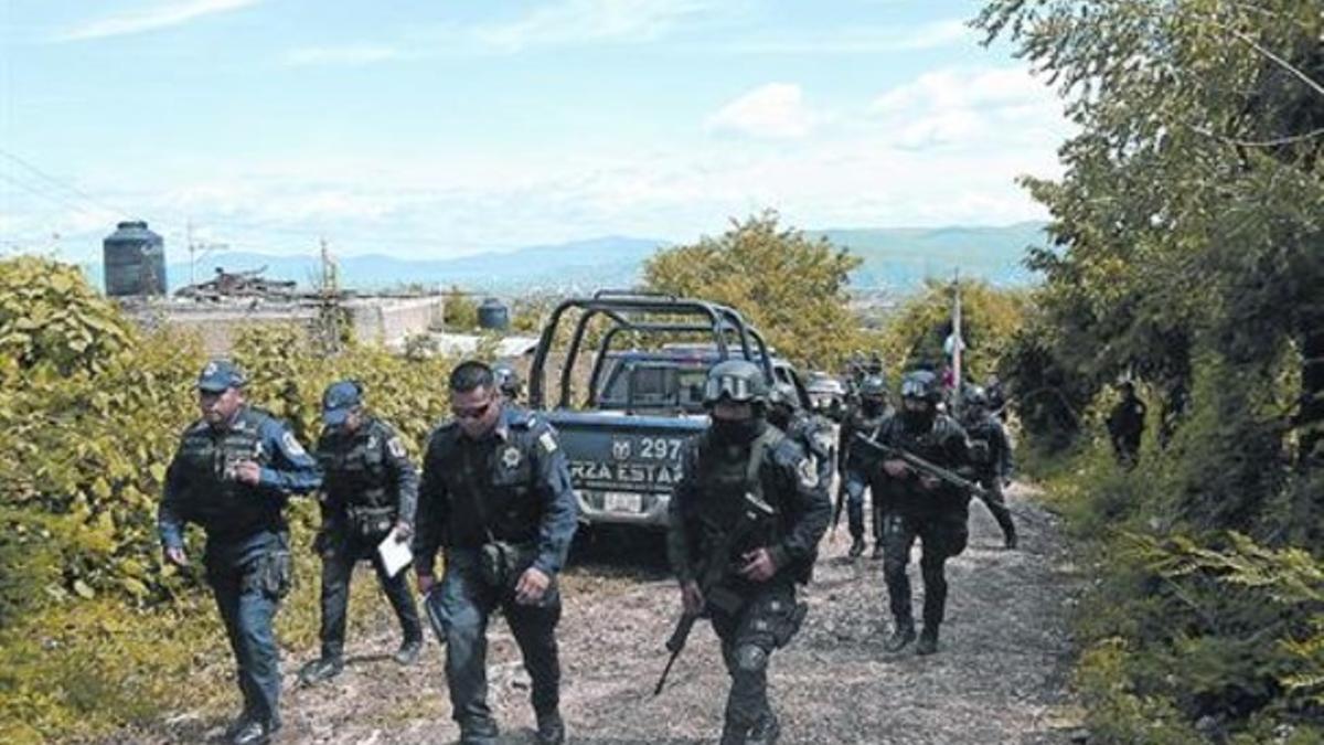 Policías mexicanos en la colonia La Parota, a las afueras de Iguala, donde fueron halladas las fosas.