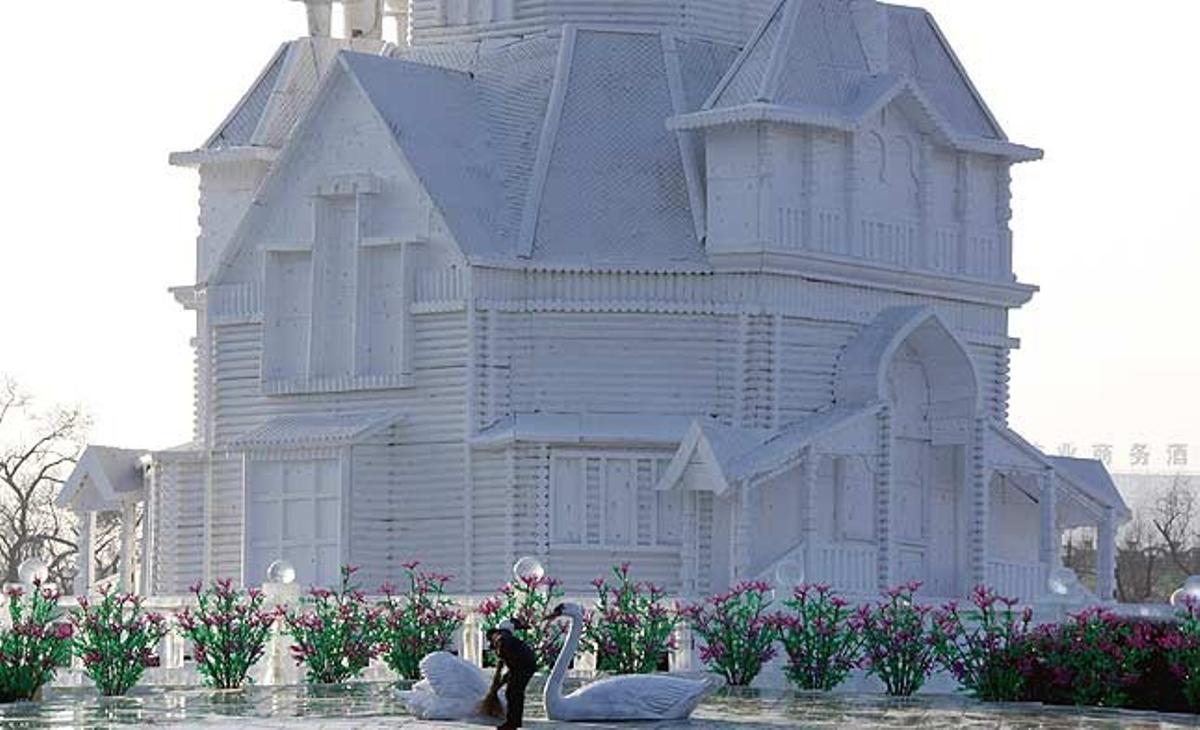 Una dona escombra davant d’una escultura de neu a la ciutat de Harbin (Xina).