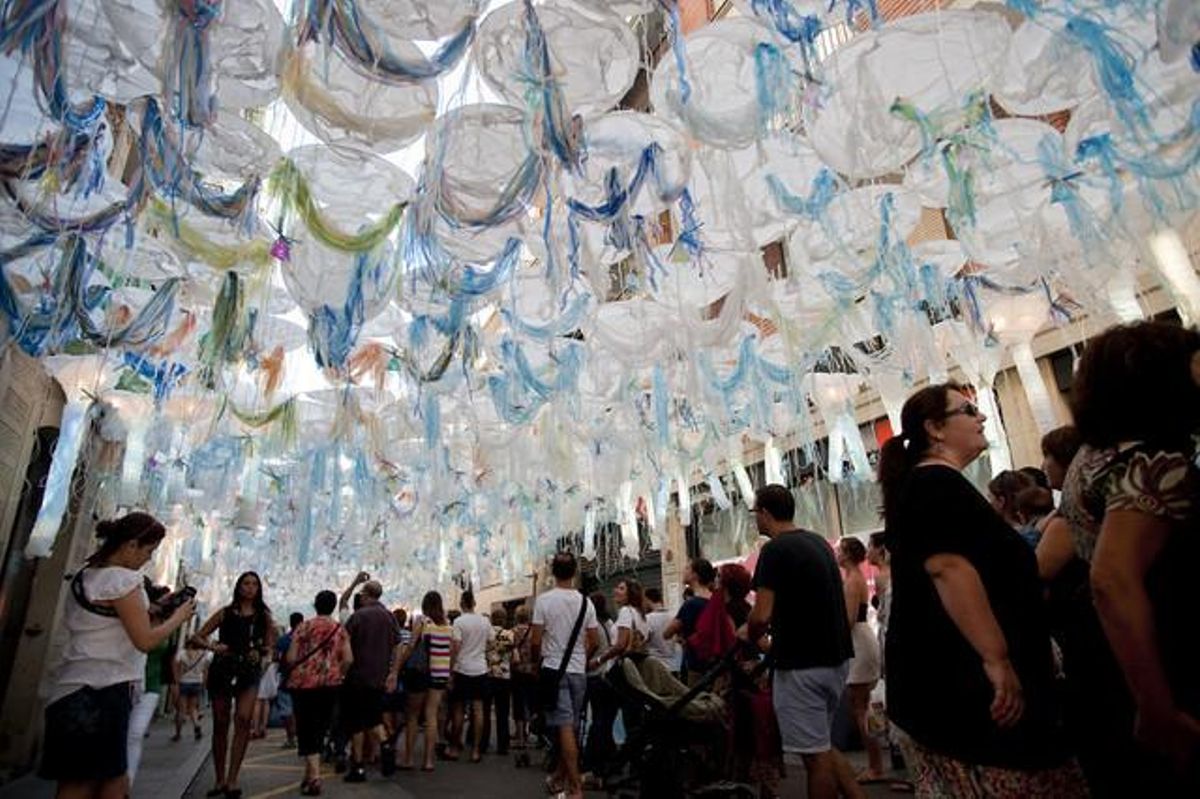 Vianants sota el decorat del carrer de Joan Blanques de Dalt.
