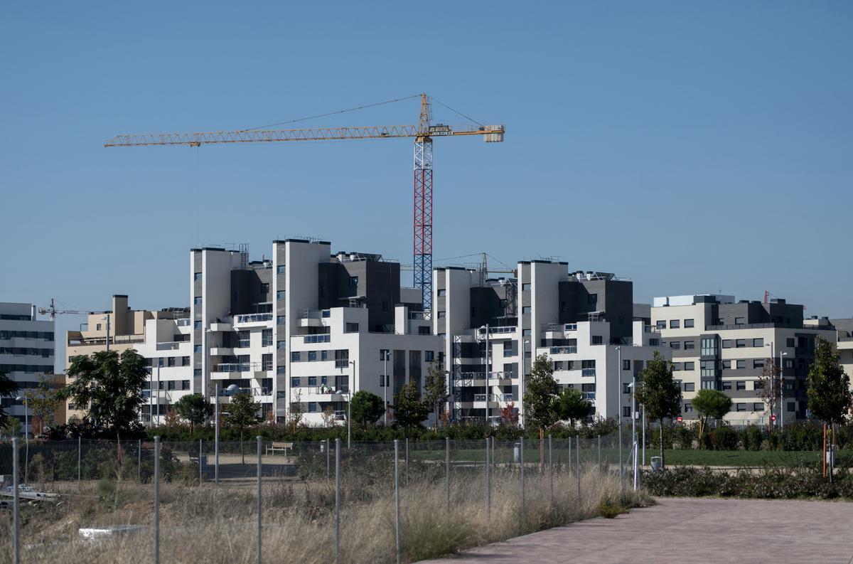 Archivo - Una grúa en una zona de construcción de viviendas.