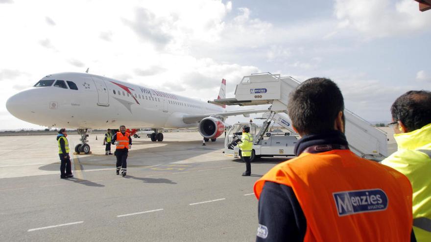 Varios trabajadores atienden un avión en el aeropuerto de San Javier