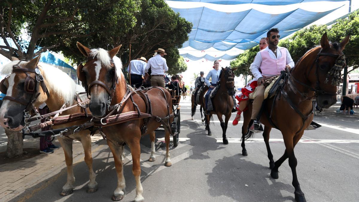 Coche de caballos y jinetes en el Real de la Feria