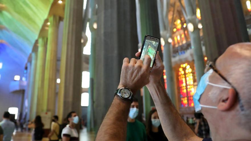 Un hombre toma una foto en la Sagrada Familia.
