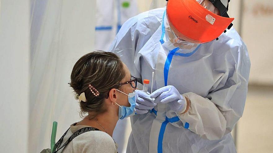 Un médico atiende a un paciente para realizarle una prueba PCR.