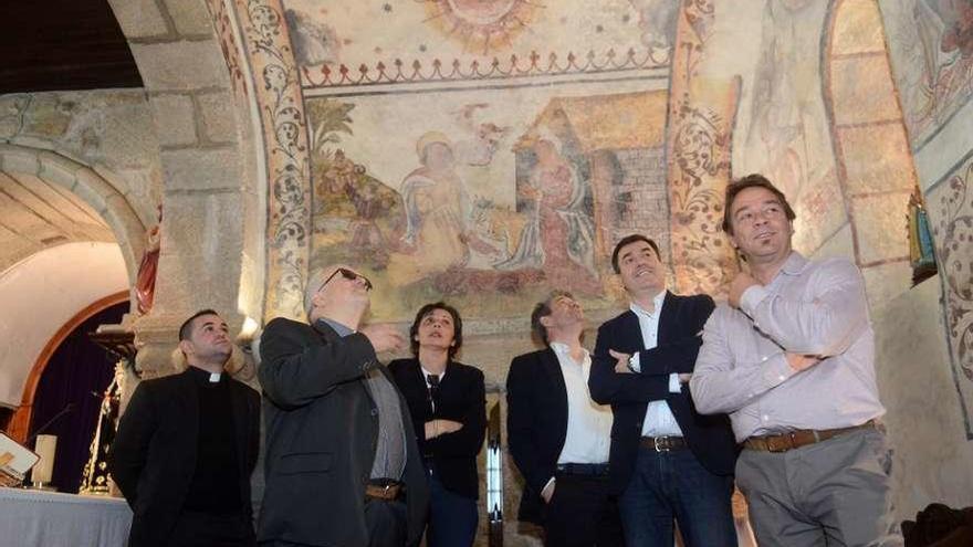 El conselleiro Román Rodríguez y el alcalde de Meis contemplan dos detalles de la bóveda policromada de Santo Tomé. //N.P.