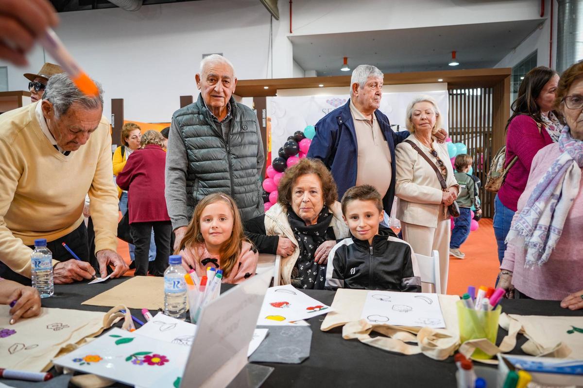 Marcos y Pilar, en el centro, junto a sus nietos Ariadna y Alejandro, en un taller de pintura de bolsas, este domingo en Ifeba.