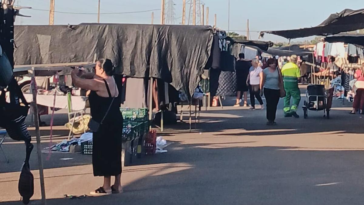 Uno de los pasillos del mercadillo, con clientes asomándose a los puestos.