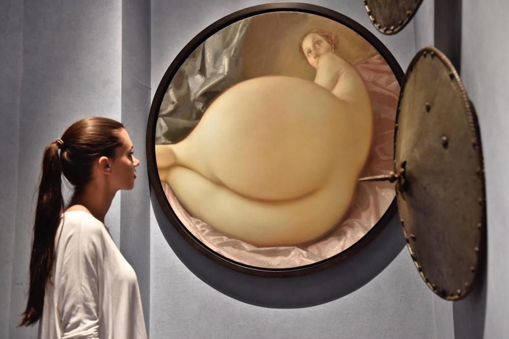 Una visitant mira l'obra "Nu en un mirall convexa", de John Currin, a Florència